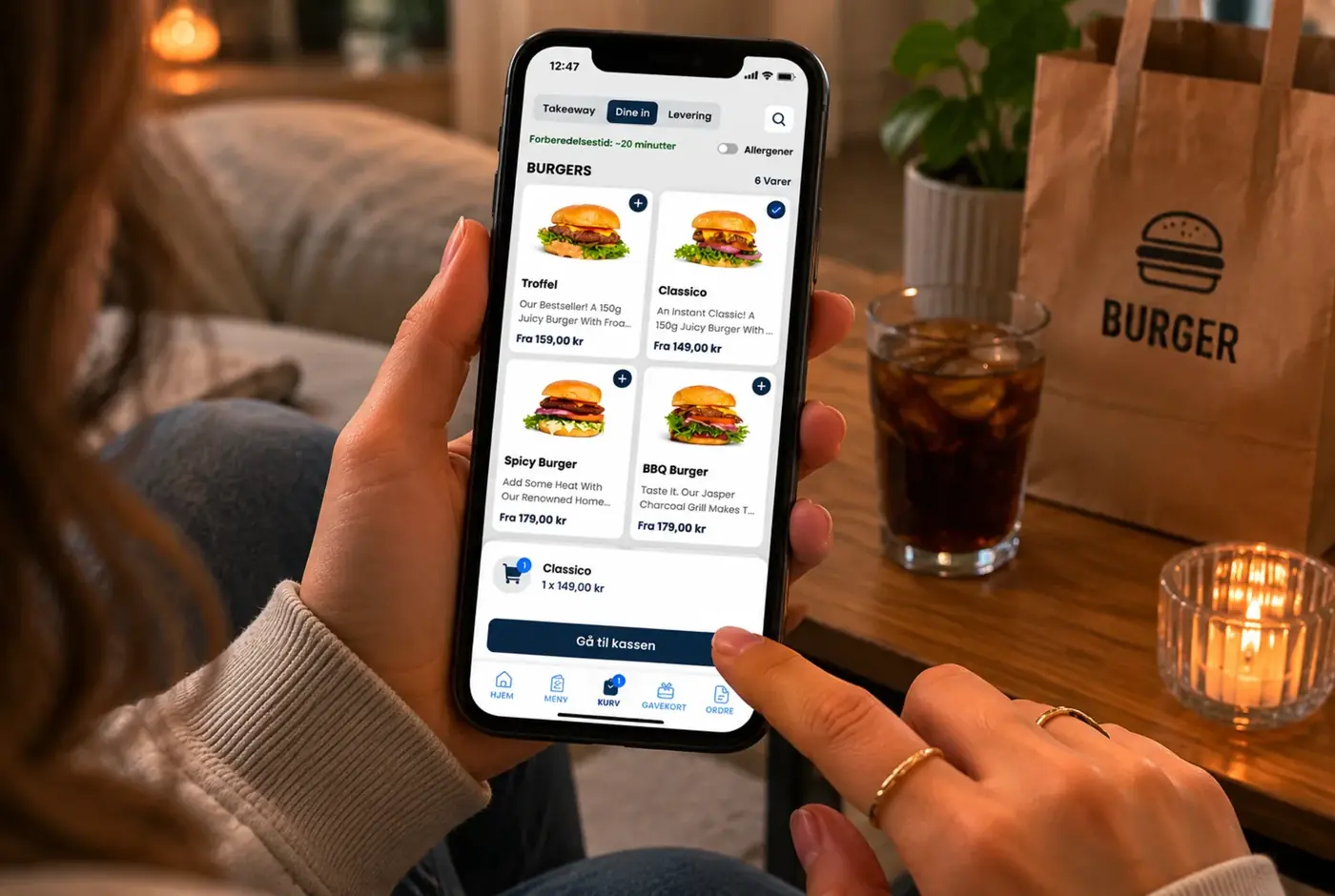 Kunde bruker AGI Order takeaway-app på mobil hjemme i sofa